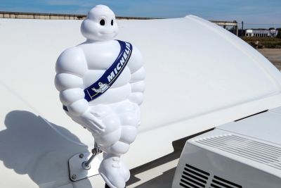 Entspannt sitzt das Michelin Männchen auf dem Lkw-Dach.