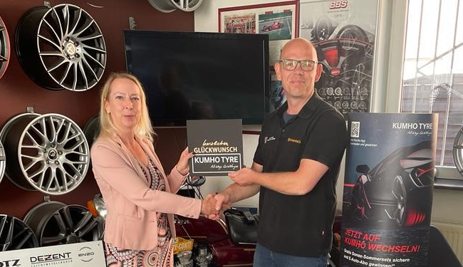 Andrea Brix, Kumho Tyre Vertrieb gratuliert Ralf Heberer, Geschäftsführer Reifen Center Ralf Heberer.