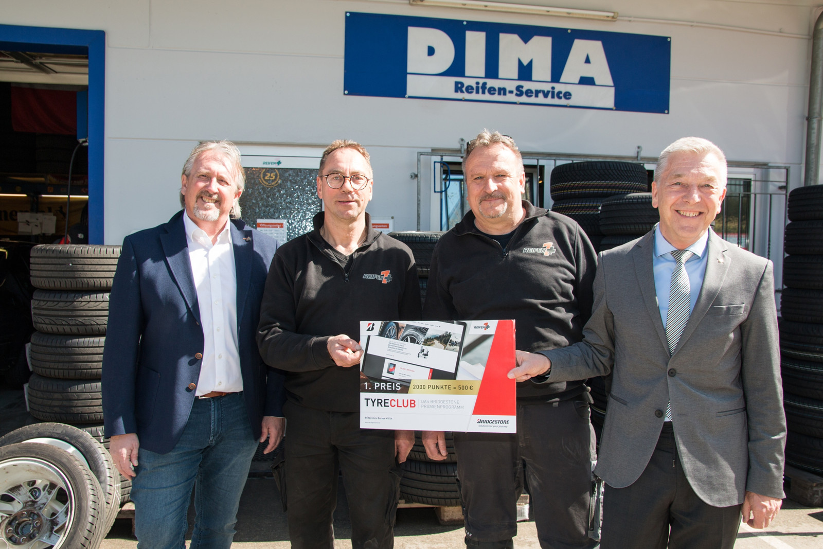 Die Inhaber von DIMA Reifenservice, Andreas Dieter (2.v.r.) und Günter Manz (2.v.l.), gewannen bei der Bridgestone Verlosung den ersten Preis.